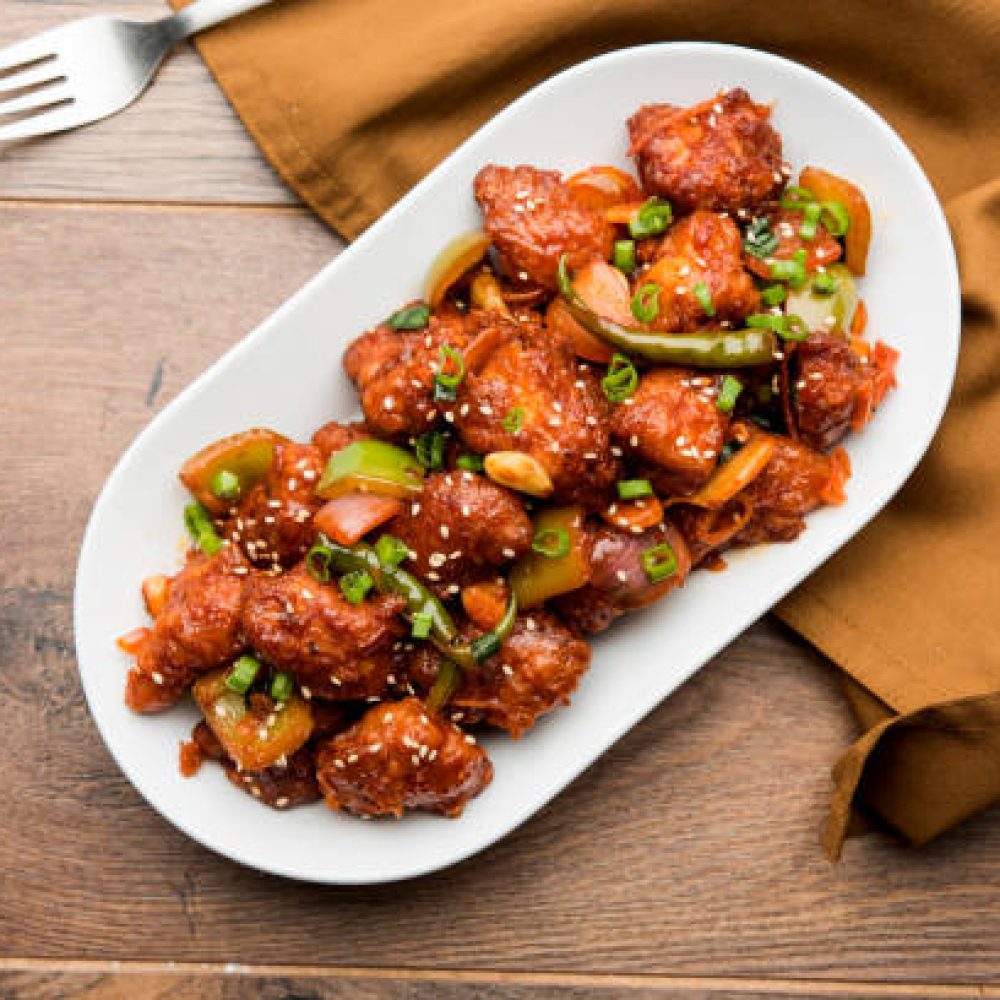Indian Chilli Chicken dry, served in a plate over moody background. Selective focus